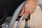 Handicapped man\'s hand pushing wheel of wheelchair