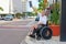 Handicapped man in a wheelchair hailing a taxi waving newspaper