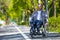 Handicapped man in wheelchair riding on street road, outdoor leisure for disable guy.