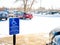 Handicapped parking sign posted in snow covered parking lot