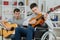 Handicapped teenager playing guitar with friend