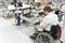 Handicapped worker in a wheelchair assembling electronic compone