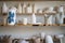 Handicraft ceramic crockery, craft pottery tableware on shelves in creative studio or potter store