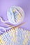 Handicraft needlework concept - hand-knitted item with knitting needles and thread in heart shape on purple background