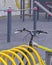 Handlebar and frame of a sports bicycle strapped to a parking place near a workout area