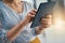 Handling business on-the-go. Closeup shot of a businesswoman working on a digital tablet in an office.