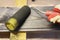 Handling a pine wood plank with a dark stain using a foam roller. Carpentry and painting works