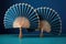 handmade bamboo hand fans placed diagonally on a blue background