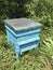 A handmade bee hive blue with flowers