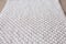 Handmade beige macrame pattern background. Macrame texture, ECO friendly, modern knitting. Macrame rug on wooden table