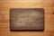 Handmade black walnut wooden chopping board with traces of knife carving on the table.