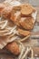 Handmade bread with bran and ears of wheat, wooden background