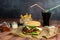 Handmade burger with fries and coke with straws on dark background