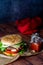 Handmade burger with fries with ketchup and red cloth on dark background