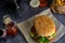 Handmade burger with fries with ketchup and red cloth on dark background