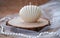 Handmade candles in the shape of a shell. Soy beige candles on wood, tulle and pearl background