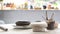 Handmade ceramic dish ware and pottery shaping tools on stone table in creative studio