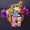 Handmade colored flowers origami bouquet paper craft art in a basket with in the studio on colored background macro