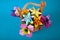 Handmade colored paper flowers origami bouquet paper craft art in a basket with grass in the studio on colored aqua