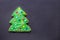 Handmade cookie like a decorated christmas tree on black with copy space