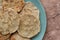 Handmade corn tortillas on green plate on a stone background top view