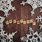 Handmade crochet snowflakes on wooden ground with wooden letters