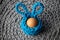 Handmade crochet turquoise Easter basket with egg on gray background