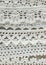 Handmade crocheted cotton organic lace ribbons on linen background. White original organic crochet frame, Knitted pattern backdrop