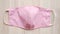 Handmade face mask made out of cotton fabric with beautiful pink color for extra protection from virus and disease