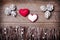 Handmade from felt hearts on wooden background. Craft arranged from sticks, twigs, driftwood and pine cones white and shiny.