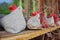 Handmade felt hens on wooden bench in front of old farmhouse window. Easter decoration.