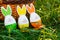 Handmade funny creative eggs lies on green grass next to natural basket at sunny spring day. Happy Easter! Egg hunt, decoration