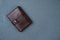 Handmade genuine leather wallet on dark concrete background with copy space