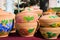 Handmade and handpainted ceramic clay jugs, pots with covers, bright floral pattern