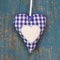 Handmade heart shape against blue wooden surface.