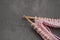 Handmade and hobby tools. Pink Wire bobbin Knitting Wool and Wooden Needles over Gray Background. Copy space for Text. hobby and H