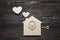 Handmade home symbol with lock-heart and key on wooden background with copy space.