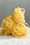 Handmade italian pasta - tagliatelle on floury background