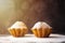 Handmade muffins with powdered sugar on the black background. Sunshine beams and sunlight, bokeh with selective soft focus. Place