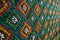 Handmade multicolor carpet with rhombus ornament, braided mat, closeup, texture background