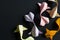 Handmade paper craft origami gold yellow pink koi carp fishes on black background in the right corner. Top view, copy space