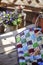 Handmade patchwork blanket on wooden table with spring flowers on background
