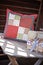 Handmade patchwork cushion with sewing tools on wooden table