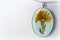 Handmade pendant made of epoxy resin and coltsfoot flower close-up