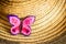 A handmade pink felt butterfly sits on a straw women`s hat on the left. Close-up, nobody, summertime