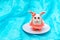 Handmade plasticine Easter bunny in the shape of an egg with ears and in a pink skirt on a white plate on a blue