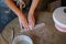 Handmade pottery creation: female craftswoman hands working with wet clay on wooden table in studio