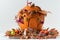 Handmade pumpkin house decorated with fallen leaves, flowers and miniature animals on the white background. Autumn background for