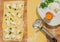 Handmade ravioli dough with fresh egg,cheese,parsley and wheel dough cutter placed on wooden table.