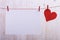 Handmade red felt hearts and white paper hanging on a rope with clothespins. Concept, banner, copy space, form